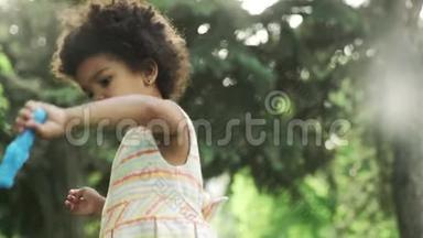 非洲裔美国小女孩在公园里玩肥皂泡。